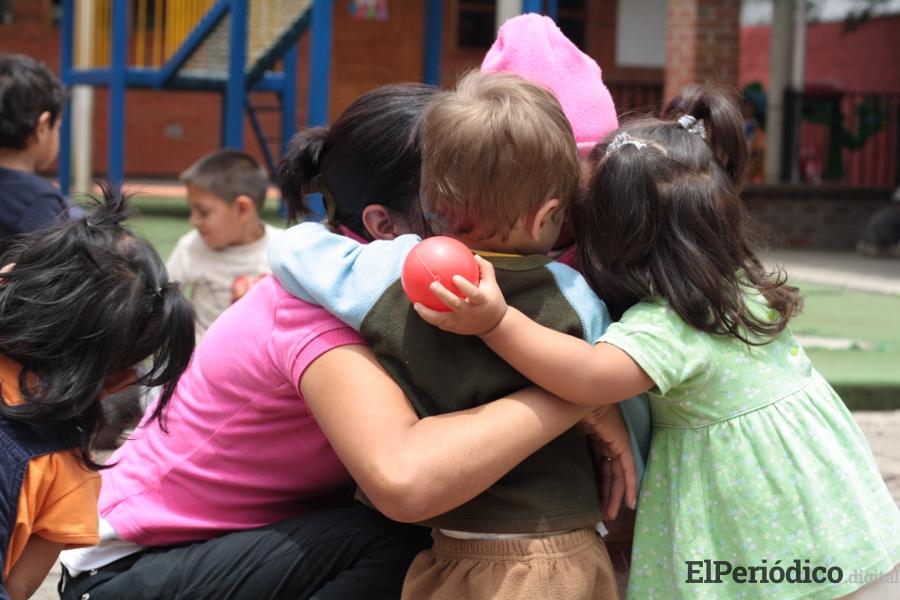 Tenemos que ayudar y proteger a la infancia 3 niños abrazándose en el patio del colegio